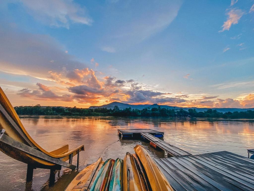 Sunset over the Kampot River with mountains and kayaks on the dock